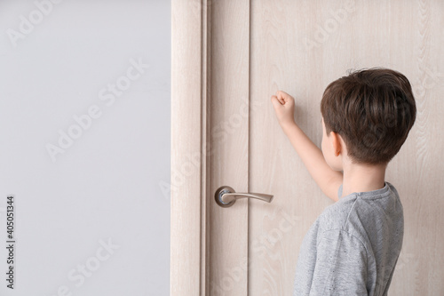 Little boy knocking at closed door