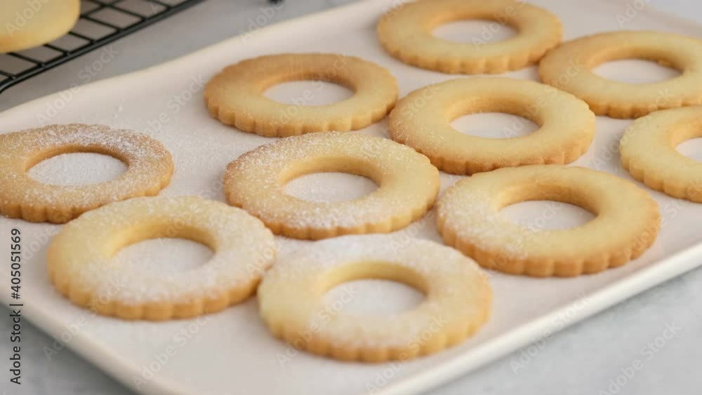 Female hands lay out hot cookies on a plate. Female hands a making homemade biscuit shortbread cookies with jam. Kurabye cookies with raspberry jam. Christmas cookies with jam. Female hands lay out hot cookies on a plate. Female hands a making homemade biscuit shortbread cookies with jam. Kurabye cookies with raspberry jam. Christmas cookies with jam.