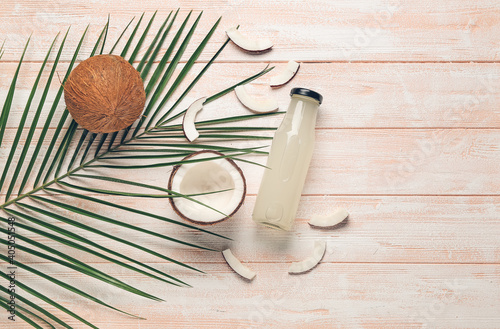 Composition with bottle of fresh coconut water on wooden background
