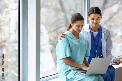 Female doctors with laptop in clinic