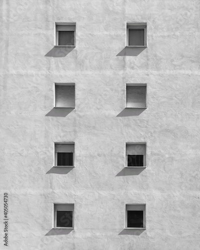 grayscale photo of windows on white facade of a building photo