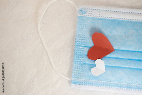 red heart on a mask on valentine's day on a white isolated background. heart surgical mask with place for inscription, mock up, copy space