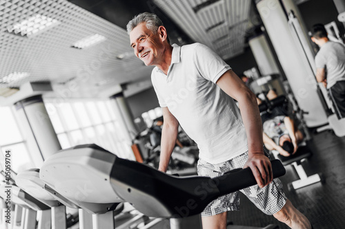 Cardio. The older man smiles and performs a cardio exercise