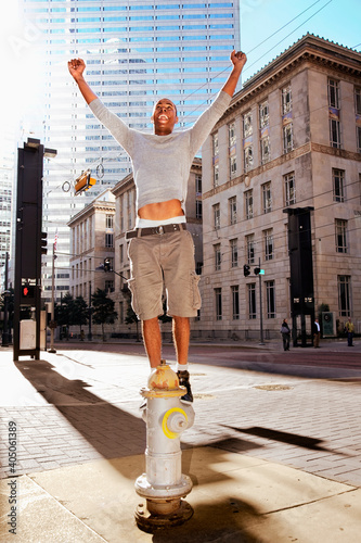 Man standing on fire hydrant on street corner