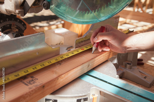 Mixed race man measuring wood on saw photo