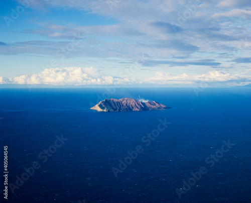 Aerial of White Island - Volcanic Island surrounded by blue ocean and clouds photo