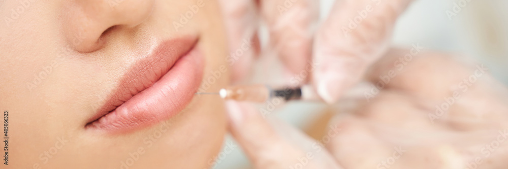 Lip injection at spa salon. Doctor hands. Closeup view. Pretty female patient. Beauty treatment. Healthy skin procedure. Young woman lifting. Facial treatment. Dermatology detox therapy. Rejuvenation Lip injection at spa salon. Doctor hands. Closeup view. Pretty female patient. Beauty treatment. Healthy skin procedure. Young woman lifting. Facial treatment. Dermatology detox therapy. Rejuvenation