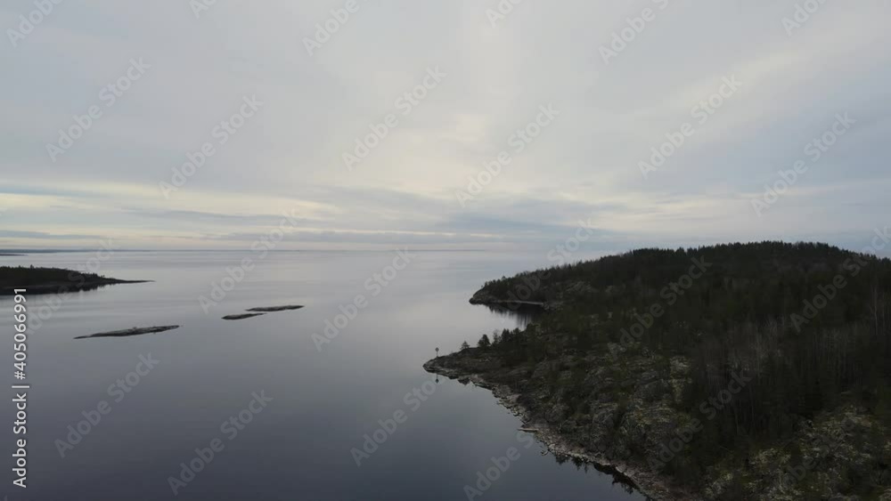 Aerial flying up above the calm lake water. Evening time Horizon and distance islands scenic. Aerial flying up above the calm lake water. Evening time Horizon and distance islands scenic.