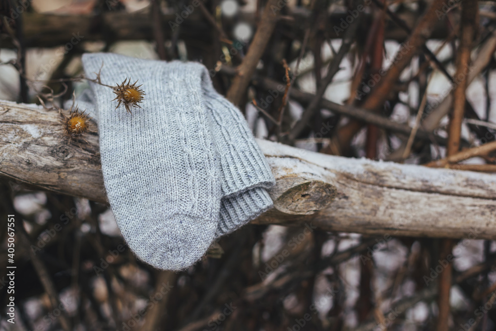 A pair of grey hand knitted socks on a dark rustic background.