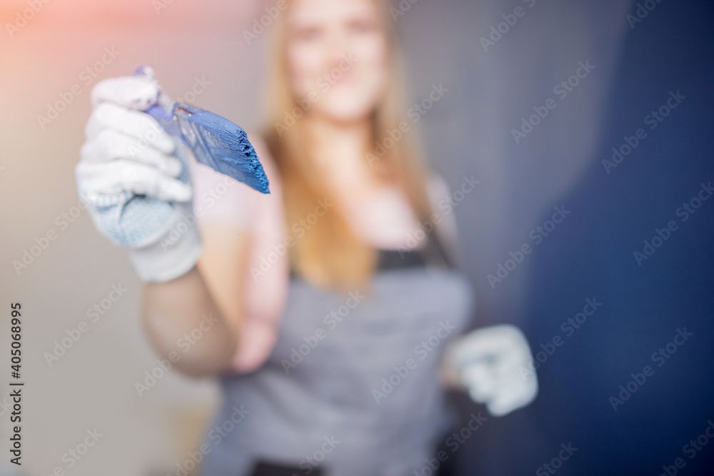 Painter worker woman using blue paint brush working in new house Painter worker woman using blue paint brush working in new house