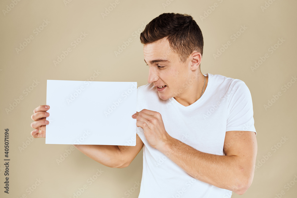 man in white t-shirt sheet of paper in hands Copy Space cropped view beige background man in white t-shirt sheet of paper in hands Copy Space cropped view beige background