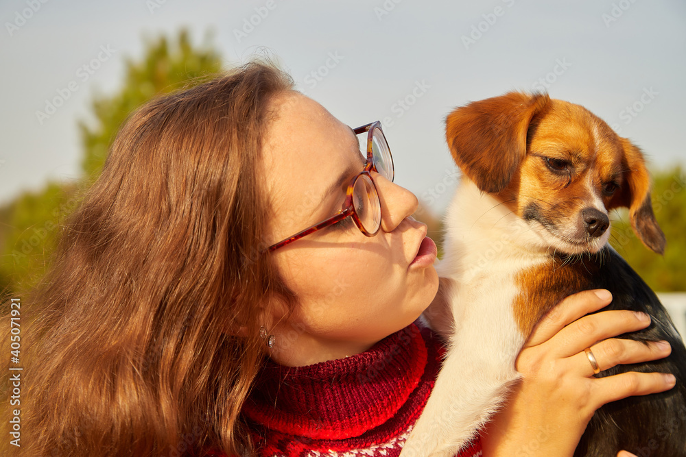 Cute girl with long hair with dog in the autumn sunny day. Friendship woman and dog.