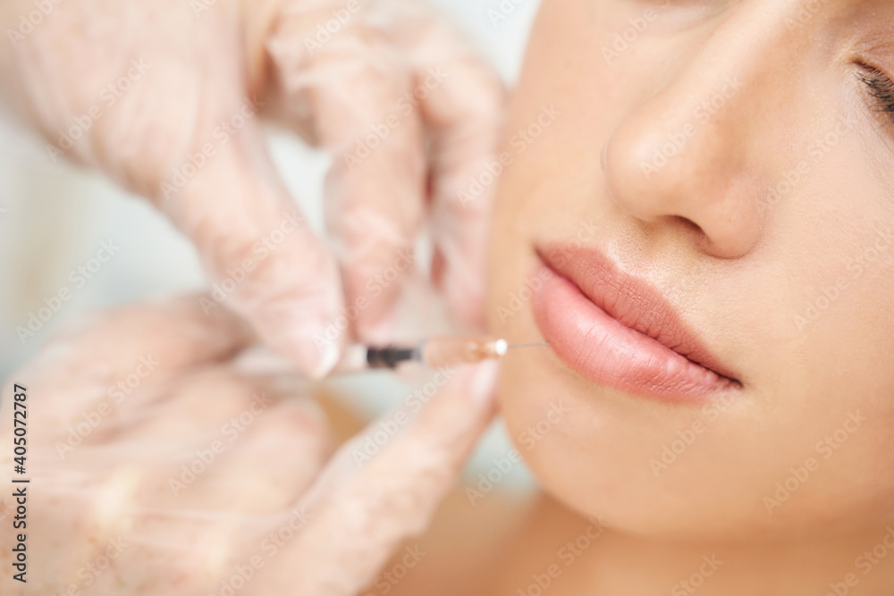 Lip injection at spa salon. Doctor hands. Closeup view. Pretty female patient. Beauty treatment. Healthy skin procedure. Young woman lifting. Facial treatment. Dermatology detox therapy. Rejuvenation Lip injection at spa salon. Doctor hands. Closeup view. Pretty female patient. Beauty treatment. Healthy skin procedure. Young woman lifting. Facial treatment. Dermatology detox therapy. Rejuvenation