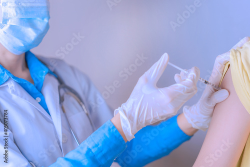 Doctor holding syringe with COVID-19 vaccine for injection to patient