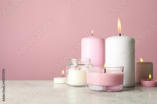 Scented candles for relax on white table against pink background