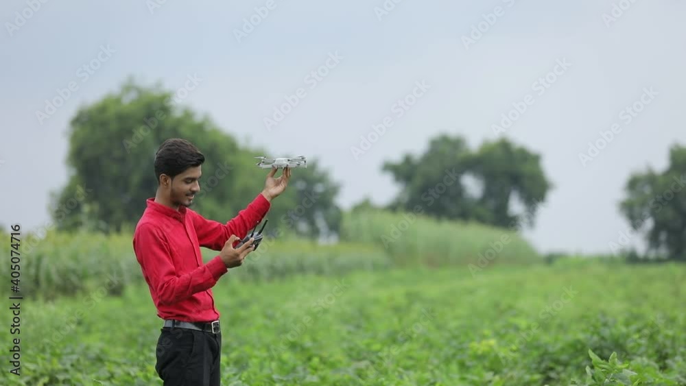 Indian agronomist holding drone and remote in hand at agriculture field Indian agronomist holding drone and remote in hand at agriculture field
