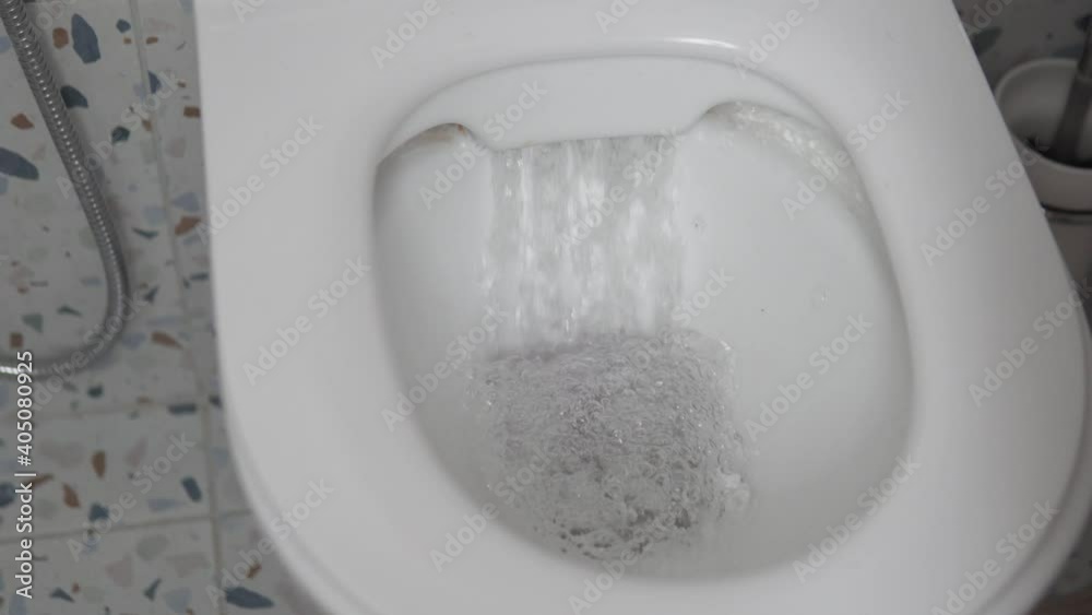 Close up of a water with paper flushing down into the toilet bowl in bathroom. Stylish modern toilet