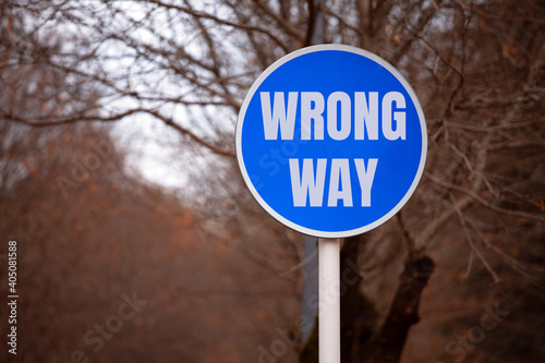 Blue Roadside Sign with the Inscription WRONG WAY in the City Park. The Concept Of Motivation.