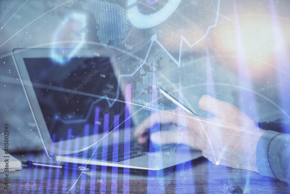 Double exposure of man's hands holding and using a digital device and forex graph drawing. Financial market concept.