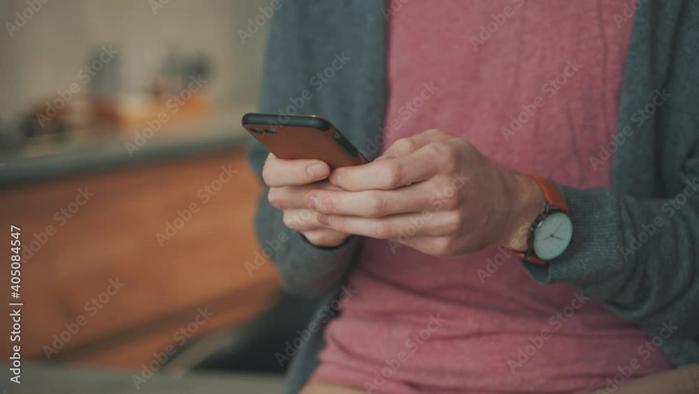 Telecommuting with a smartphone, sending and receiving messages.Close-up. Young male teleworking from home. Telecommuting with a smartphone, sending and receiving messages.Close-up. Young male teleworking from home.