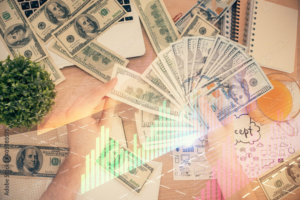 Obraz premium Multi exposure of financial graph drawing hologram and USA dollars bills and man hands. Analysis concept.