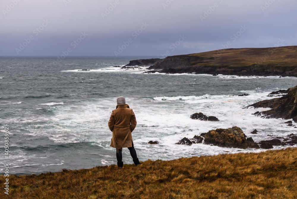 A woman enjoys a view of the Atlantic storm on the shore of Malin Beg, in the small village of Gaeltacht, south of Glencolumbkille, County Donegal, Ireland.