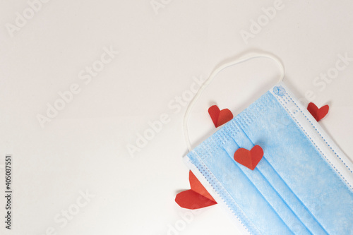 red heart on a mask on valentine's day on a white isolated background. heart surgical mask with place for inscription, mock up, copy space