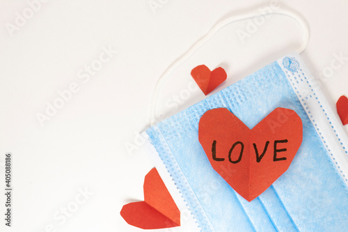 red heart on a mask on valentine's day on a white isolated background. heart surgical mask with place for inscription, mock up, copy space