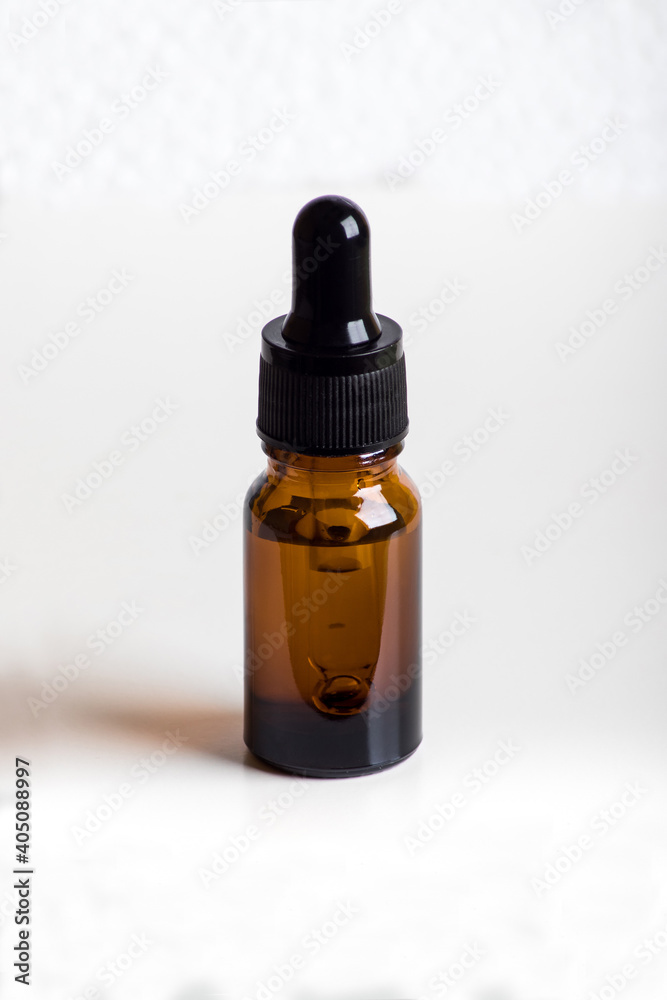 Glass dropper on light background, detail of cosmetic product Glass dropper on light background, detail of cosmetic product