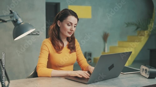 Woman preparing to work from home, opening laptop and typing a message