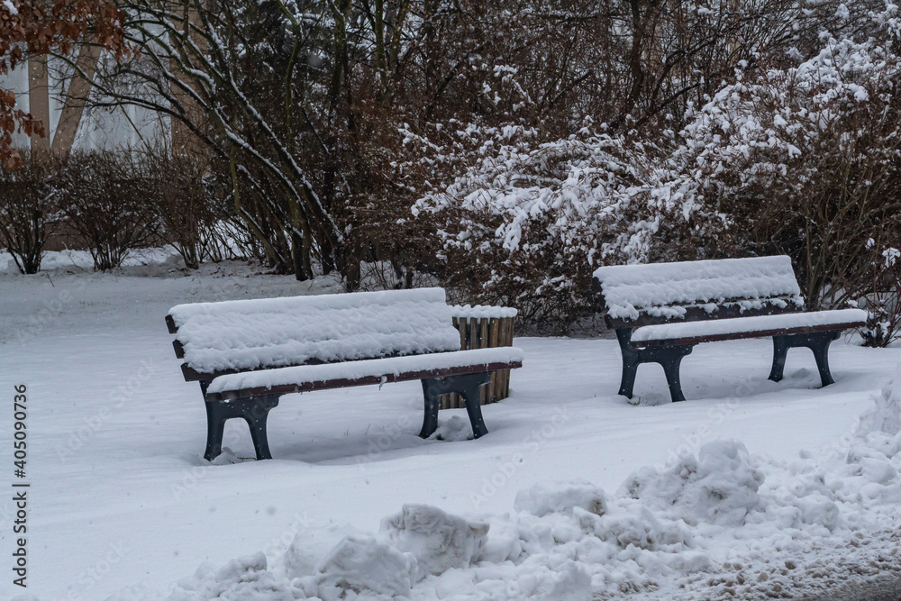 Zwei eingeschneite Sitzbänke im Winter