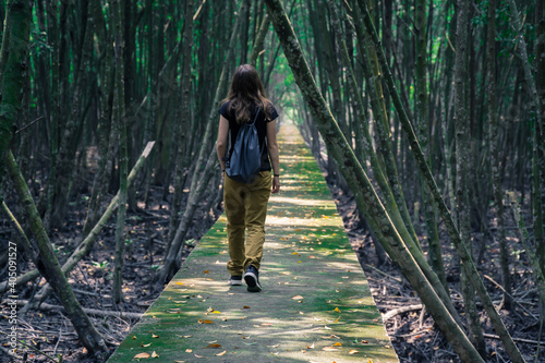 Woman walking through a mangrove forest in a National Park in Malaysia