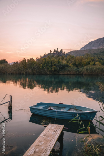 Blue boat of calm body of water during sunset