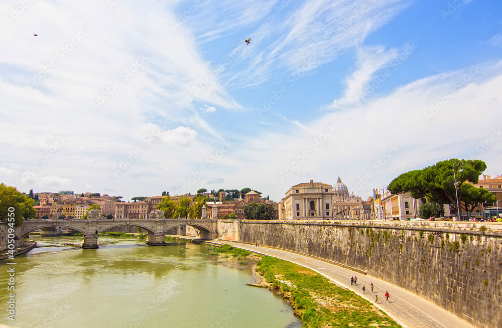 Fototapeta premium Beautiful view of Tiber river and old stone bridge near Castel Sant'Angelo with ancient buildings on background, Rome, Italy. Representative picture of the enermal city
