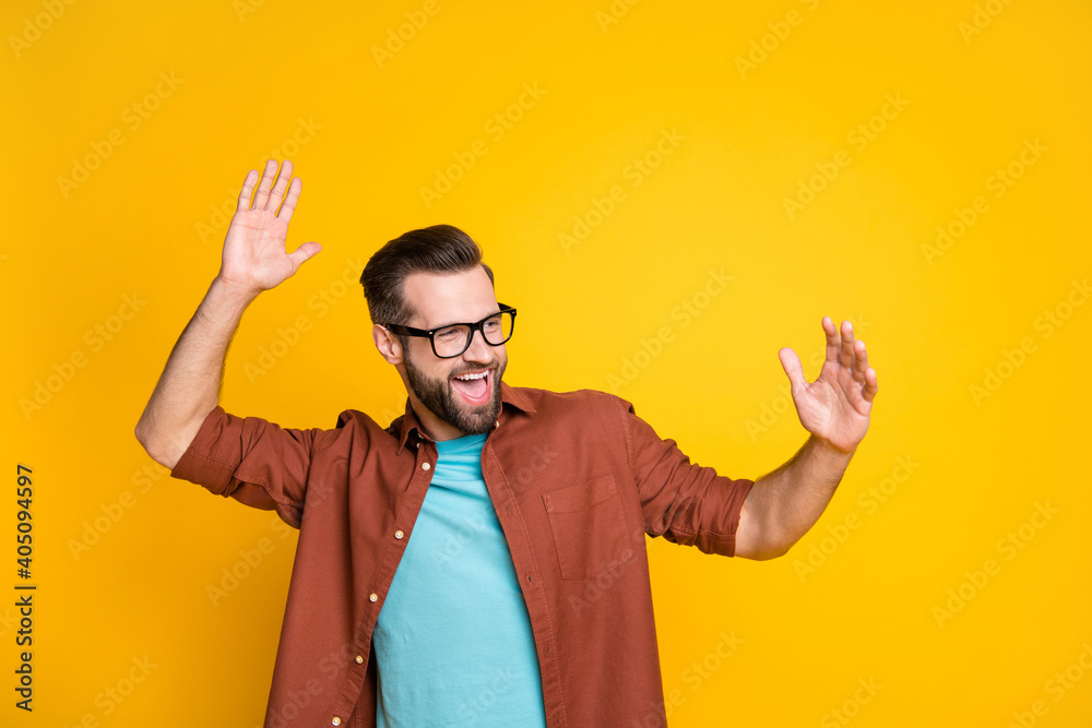 Photo of happy funky excited young bearded man dance raise hands look copyspace isolated on yellow color background Photo of happy funky excited young bearded man dance raise hands look copyspace isolated on yellow color background