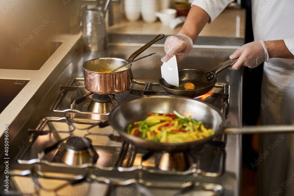 Hard-working chef preparing a delicious meal on stove