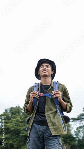 young Asian man traveler with backpack in reservoir