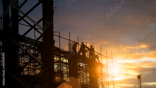 Silhouette Engineer and construction team working at site over blurred  industry background with Light fair Film Grain effect.
