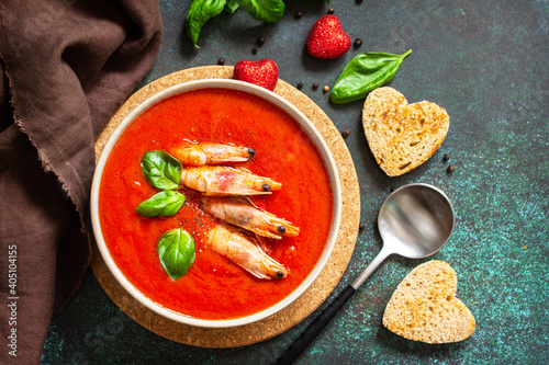 Traditional homemade gazpacho cold soup. Tomato soup puree gazpacho with tomatoes served seafood on a stone background.