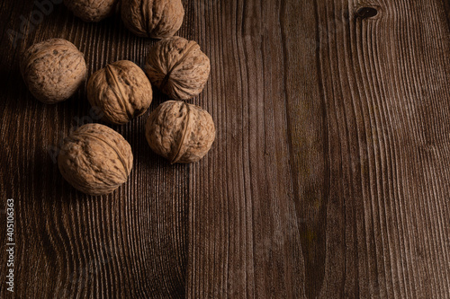 Several walnuts laying on the brown wooden surface. Nutbrown monochromatic background. photo