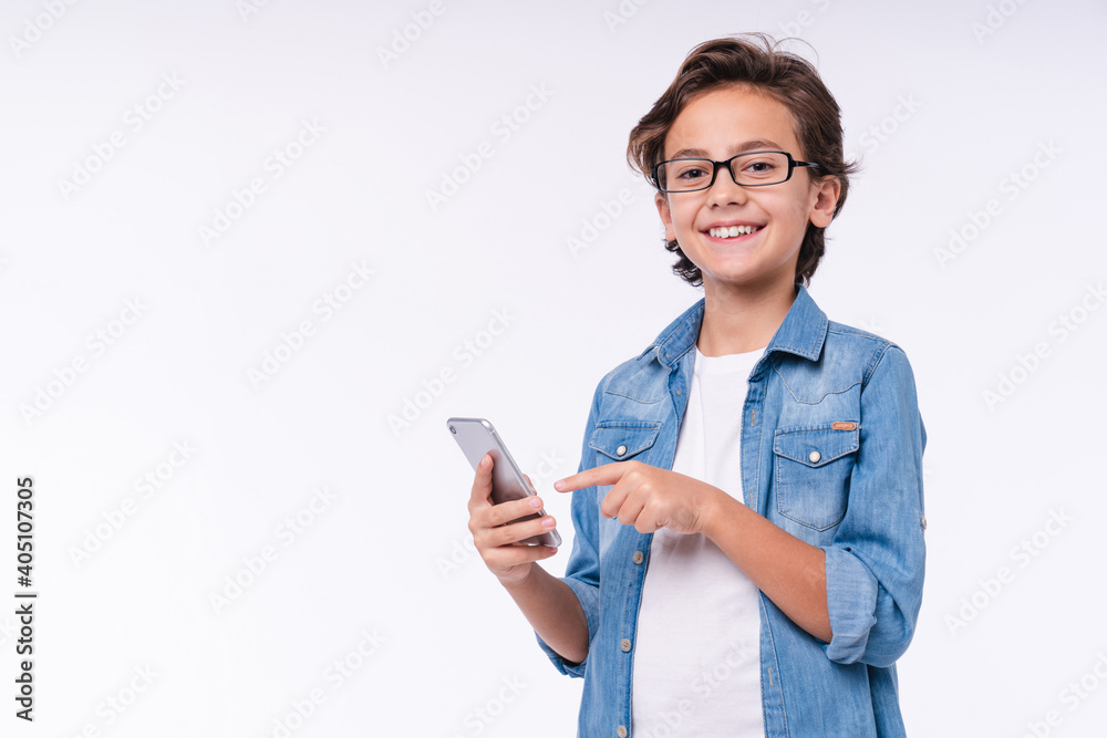 Happy little child pointing at smart phone isolated over white background Happy little child pointing at smart phone isolated over white background