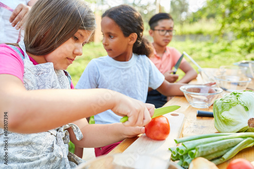 Children at the summer camp cooking class prepare salad