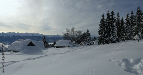 Famous small Zajamniki village in Alps mountains, Slovenia. Beautiful wooden cabins covered with snow. Amazing Pokljuka plateau in winter season. Left pan, wide angle