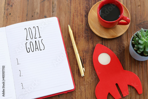 Business concept of top view 2021 goals list with notebook over wooden desk