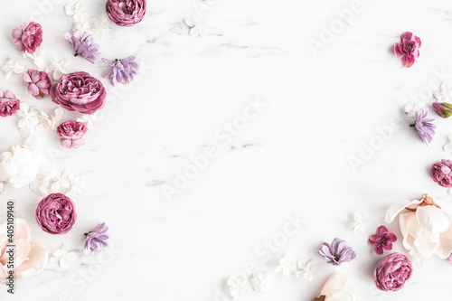 Flowers composition. White and purple flowers on marble background. Flat lay, top view