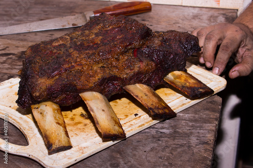 Bone-in beef rib smoked in Pit Smoker seasoned with Dry Rub. Featuring rustic beef. Smoked Ribs. Gastronomic photo of barbecue. photo