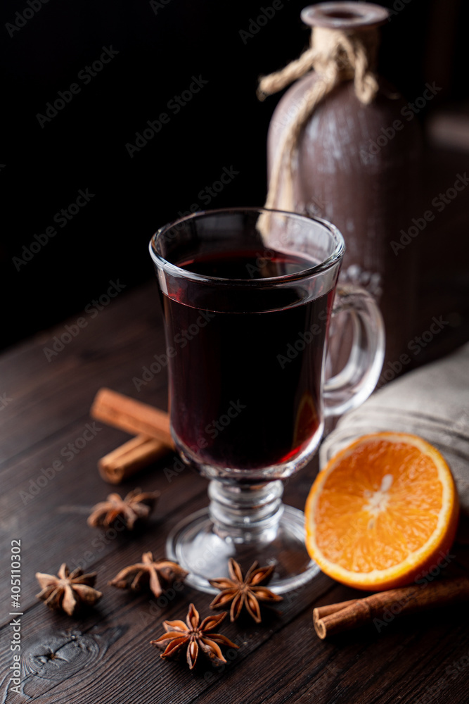 Hot autumn grog in a glass with honey and spices, ingredients around, laying on a wooden background Hot autumn grog in a glass with honey and spices, ingredients around, laying on a wooden background