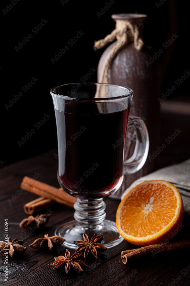 Hot autumn grog in a glass with honey and spices, ingredients around, laying on a wooden background Hot autumn grog in a glass with honey and spices, ingredients around, laying on a wooden background