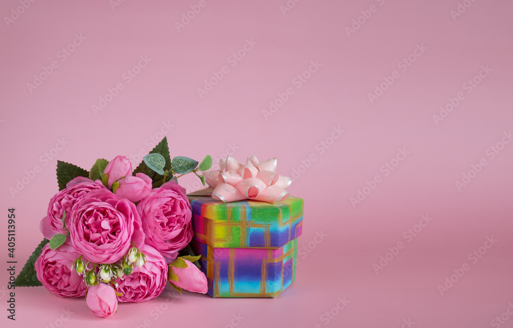 Gift box and bouquet of flowers on pink background. The concept of congratulations for Mother's Day, Valentine's Day, birthday, International Women's day and other holidays. Copy space
