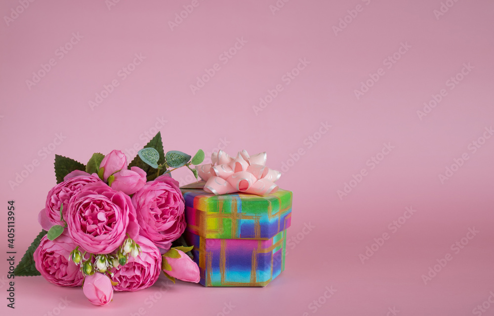 Gift box and bouquet of flowers on pink background. The concept of congratulations for Mother's Day, Valentine's Day, birthday, International Women's day and other holidays. Copy space Gift box and bouquet of flowers on pink background. The concept of congratulations for Mother's Day, Valentine's Day, birthday, International Women's day and other holidays. Copy space